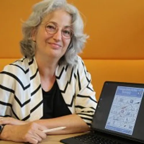 Portret van Monica met een laptop, zij is zakelijk tekenaar en weet ingewikkelde vraagstukken te vertalen naar aansprekende tekeningen