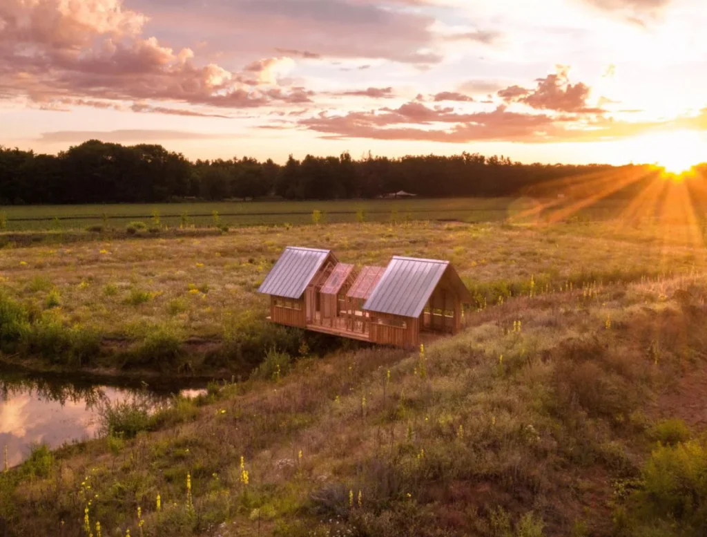 Houten vakantiehuisjes in veld bij zonsondergang
